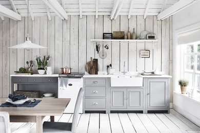Design ideas for a medium sized rural grey and white single-wall kitchen/diner in London with a belfast sink, grey cabinets, grey floors, painted wood flooring, beaded cabinets, wood splashback, white appliances and no island.