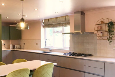 エセックスにある中くらいなおしゃれなキッチン (珪岩カウンター、ピンクのキッチンパネル、クッションフロア、茶色い床、ピンクのキッチンカウンター) の写真
