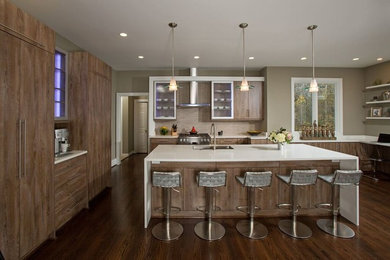 Example of a minimalist u-shaped kitchen design in DC Metro with flat-panel cabinets, medium tone wood cabinets, quartz countertops, beige backsplash, white countertops and an island