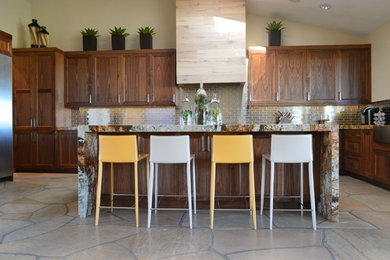 Large trendy u-shaped travertine floor and beige floor eat-in kitchen photo in Phoenix with recessed-panel cabinets, medium tone wood cabinets, an island, a farmhouse sink, granite countertops, beige backsplash, metal backsplash and stainless steel appliances