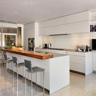 Design ideas for a contemporary kitchen in London with an integrated sink, flat-panel cabinets, grey cabinets, stainless steel worktops, beige splashback, stainless steel appliances, an island and beige floors.