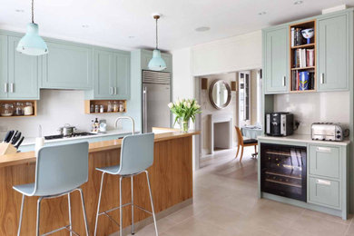 This is an example of a contemporary kitchen in London with a double-bowl sink, blue cabinets, engineered stone countertops, white splashback, stainless steel appliances, porcelain flooring and white worktops.
