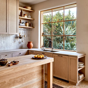 Inspiration for a large mediterranean l-shaped kitchen in Melbourne with an undermount sink, shaker cabinets, light wood cabinets, with island, beige floor and grey benchtop.