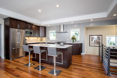 Example of a mid-sized trendy l-shaped medium tone wood floor open concept kitchen design in Other with an undermount sink, shaker cabinets, dark wood cabinets, quartz countertops, stainless steel appliances and an island
