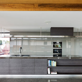 Inspiration for a contemporary galley open plan kitchen in Brisbane with a drop-in sink, flat-panel cabinets, grey cabinets, black appliances, concrete floors, with island, grey floor and grey benchtop.