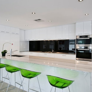 Mid-sized modern u-shaped open plan kitchen in Perth with a double-bowl sink, flat-panel cabinets, white cabinets, granite benchtops, black splashback, glass sheet splashback, stainless steel appliances, marble floors and with island.
