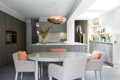 This is an example of a contemporary open plan kitchen in London with grey floors.