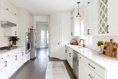 Mid-sized transitional galley medium tone wood floor and brown floor enclosed kitchen photo in Austin with an undermount sink, shaker cabinets, gray cabinets, quartz countertops, beige backsplash, porcelain backsplash, stainless steel appliances and gray countertops