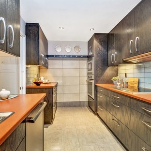 Inspiration for a small contemporary galley separate kitchen in Ottawa with a drop-in sink, flat-panel cabinets, dark wood cabinets, laminate benchtops, blue splashback, glass tile splashback, porcelain floors, beige floor and orange benchtop.