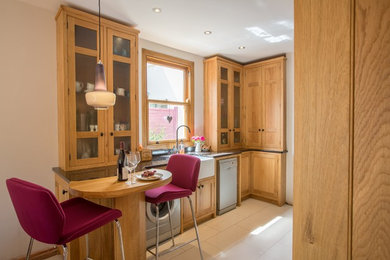 カーディフにあるヴィクトリアン調のおしゃれなダイニングキッチン (エプロンフロントシンク、インセット扉のキャビネット、淡色木目調キャビネット、御影石カウンター) の写真