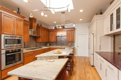 Transitional u-shaped light wood floor kitchen pantry photo in San Diego with an undermount sink, recessed-panel cabinets, medium tone wood cabinets, granite countertops, metallic backsplash, metal backsplash, stainless steel appliances and an island