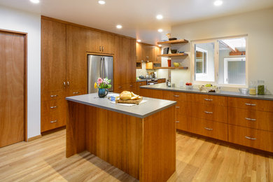 Inspiration for a large craftsman l-shaped medium tone wood floor kitchen pantry remodel in Los Angeles with a double-bowl sink, flat-panel cabinets, medium tone wood cabinets, quartz countertops, beige backsplash, mosaic tile backsplash, stainless steel appliances and an island