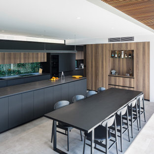 Inspiration for a modern l-shaped eat-in kitchen in Perth with a double-bowl sink, flat-panel cabinets, black cabinets, window splashback, with island, grey floor and black benchtop.