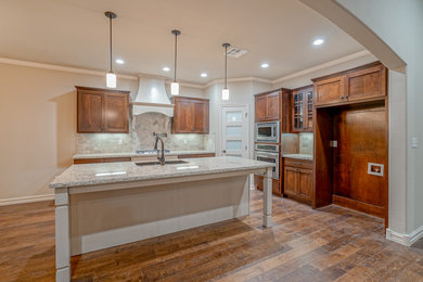 Inspiration for a mid-sized transitional u-shaped brown floor eat-in kitchen remodel in Other with an undermount sink, flat-panel cabinets, medium tone wood cabinets, granite countertops, beige backsplash and stainless steel appliances