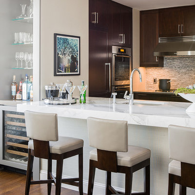 Example of a large trendy kitchen design in Boston with stainless steel appliances, shaker cabinets, dark wood cabinets, marble countertops, gray backsplash, glass tile backsplash and an island