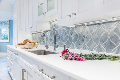 Diseño de cocina comedor contemporánea grande con salpicadero azul, salpicadero de azulejos de vidrio, electrodomésticos de acero inoxidable y dos o más islas