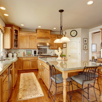 Classic American kitchen interior with brown cabinets granite counter top island