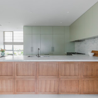 Inspiration for a mid-sized contemporary u-shaped open plan kitchen in Sydney with an undermount sink, marble benchtops, white splashback, marble splashback, black appliances, porcelain floors, white floor, white benchtop, flat-panel cabinets, green cabinets and a peninsula.