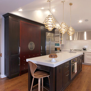 Inspiration for a mid-sized eclectic u-shaped eat-in kitchen in Raleigh with a single-bowl sink, recessed-panel cabinets, dark wood cabinets, quartz benchtops, yellow splashback, glass tile splashback, stainless steel appliances, medium hardwood floors and with island.
