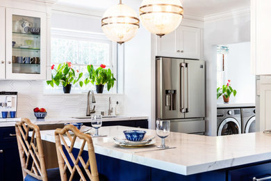 Mid-sized transitional u-shaped kitchen photo in Los Angeles with a single-bowl sink, shaker cabinets, blue cabinets, quartz countertops, white backsplash, ceramic backsplash, stainless steel appliances, a peninsula and white countertops