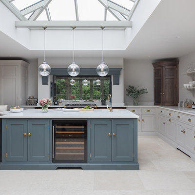 Mid-sized transitional l-shaped beige floor kitchen photo in Essex with an undermount sink, shaker cabinets, gray cabinets, mirror backsplash, stainless steel appliances, an island and white countertops