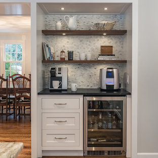 This is an example of a mid-sized transitional l-shaped separate kitchen in Boston with an integrated sink, recessed-panel cabinets, white cabinets, soapstone benchtops, multi-coloured splashback, porcelain splashback, stainless steel appliances, dark hardwood floors, with island and brown floor.