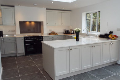 This is an example of a farmhouse kitchen in Buckinghamshire with a belfast sink, quartz worktops and glass sheet splashback.