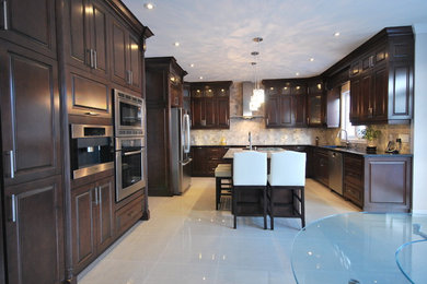 Eat-in kitchen - large traditional u-shaped eat-in kitchen idea in Toronto with an undermount sink, raised-panel cabinets, brown cabinets and granite countertops