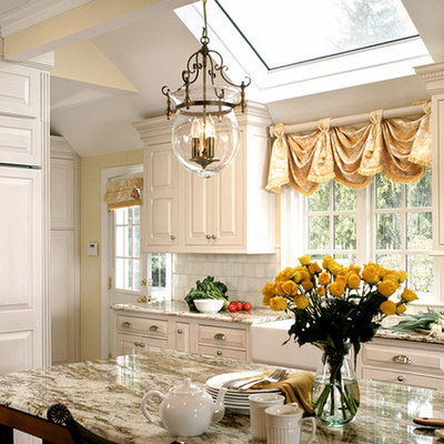 Kitchen - mid-sized traditional l-shaped dark wood floor and brown floor kitchen idea in New York with a farmhouse sink, raised-panel cabinets, white backsplash, white cabinets, marble countertops, subway tile backsplash, paneled appliances and an island