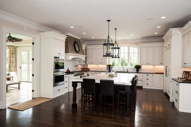 Eat-in kitchen - large traditional u-shaped dark wood floor eat-in kitchen idea in DC Metro with raised-panel cabinets, white cabinets, white backsplash, white appliances and an island