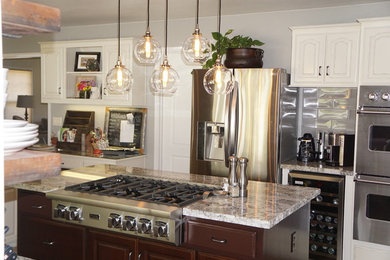 Example of a mid-sized transitional kitchen design in Other with raised-panel cabinets, white cabinets, granite countertops, gray backsplash, subway tile backsplash, stainless steel appliances and an island