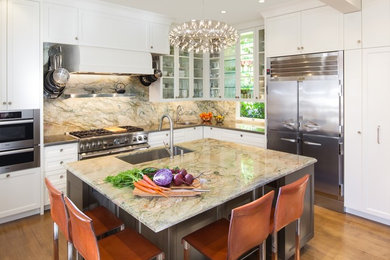 Large trendy l-shaped medium tone wood floor and beige floor eat-in kitchen photo in San Francisco with an integrated sink, glass-front cabinets, white cabinets, quartzite countertops, multicolored backsplash, stainless steel appliances, an island and stone slab backsplash