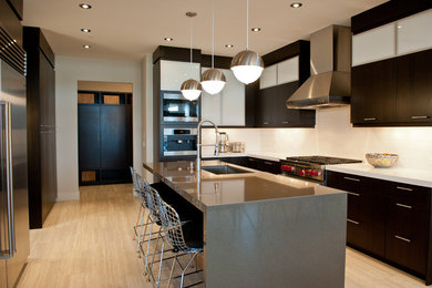Photo of a large modern u-shaped kitchen in Calgary with a submerged sink, flat-panel cabinets, dark wood cabinets, engineered stone countertops, white splashback, cement tile splashback, stainless steel appliances, porcelain flooring, an island and beige floors.