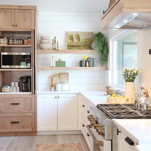 Foto di una grande cucina a L classica con ante in stile shaker, ante bianche, top in quarzo composito, paraspruzzi bianco, paraspruzzi in quarzo composito, elettrodomestici bianchi, pavimento in laminato, pavimento grigio e top bianco