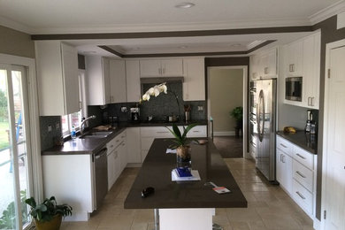 Example of a mid-sized urban u-shaped travertine floor eat-in kitchen design in Los Angeles with an undermount sink, shaker cabinets, white cabinets, quartz countertops, blue backsplash, glass tile backsplash, stainless steel appliances and an island