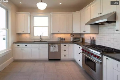 Kitchen - large craftsman l-shaped ceramic tile and gray floor kitchen idea in Portland with an undermount sink, shaker cabinets, white cabinets, quartz countertops, white backsplash, subway tile backsplash, stainless steel appliances and no island