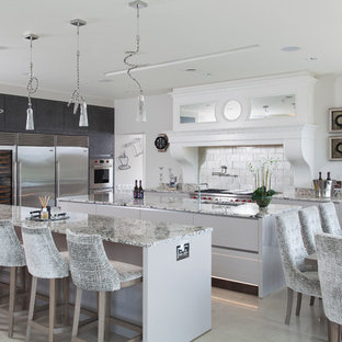 Photo of an expansive classic l-shaped open plan kitchen in Glasgow with a submerged sink, flat-panel cabinets, grey cabinets, marble worktops, grey splashback, marble splashback, stainless steel appliances, porcelain flooring, multiple islands, beige floors and grey worktops.