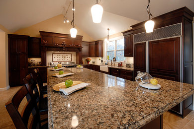 Inredning av ett klassiskt kök och matrum, med en integrerad diskho, beige skåp, svart stänkskydd, stänkskydd i keramik, rostfria vitvaror, klinkergolv i keramik och en köksö