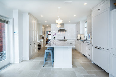 Mid-sized transitional l-shaped cement tile floor eat-in kitchen photo in Toronto with an undermount sink, shaker cabinets, white cabinets, marble countertops, white backsplash, subway tile backsplash, stainless steel appliances and an island