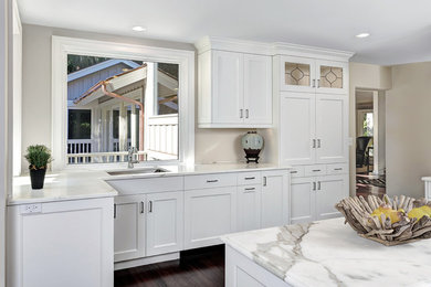 Inspiration for a transitional dark wood floor enclosed kitchen remodel in Charleston with an undermount sink, recessed-panel cabinets, white cabinets, granite countertops and an island