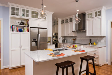 Inspiration for a mid-sized transitional l-shaped medium tone wood floor and brown floor eat-in kitchen remodel in Raleigh with an undermount sink, shaker cabinets, white cabinets, quartz countertops, gray backsplash, glass tile backsplash, stainless steel appliances, an island and white countertops