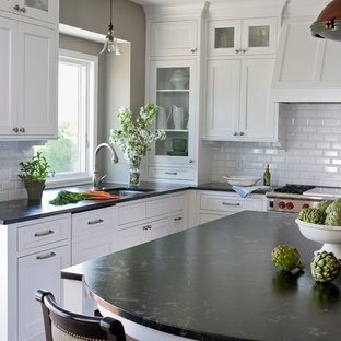 Mid-sized traditional open concept kitchen pictures - Inspiration for a mid-sized timeless l-shaped medium tone wood floor open concept kitchen remodel in Minneapolis with an undermount sink, flat-panel cabinets, white cabinets, granite countertops, white backsplash, ceramic backsplash, stainless steel appliances and an island