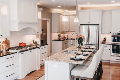 Large elegant l-shaped medium tone wood floor and brown floor open concept kitchen photo in Other with an undermount sink, flat-panel cabinets, white cabinets, quartz countertops, white backsplash, marble backsplash, stainless steel appliances, an island and black countertops