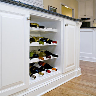 Large traditional eat-in kitchen remodeling - Inspiration for a large timeless l-shaped eat-in kitchen remodel in Raleigh with an undermount sink, raised-panel cabinets, white cabinets, granite countertops, white backsplash, subway tile backsplash, white appliances and two islands