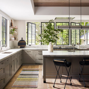 Open concept kitchen - large transitional l-shaped light wood floor and beige floor open concept kitchen idea in New York with an undermount sink, shaker cabinets, light wood cabinets, marble countertops, white backsplash, marble backsplash, stainless steel appliances, an island and white countertops