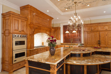 На фото: угловая, отдельная кухня в классическом стиле с фасадами с декоративным кантом и фасадами цвета дерева среднего тона с