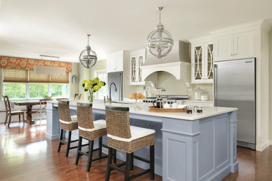 Example of a classic galley dark wood floor and brown floor kitchen design in St Louis with an undermount sink, recessed-panel cabinets, white cabinets, stainless steel appliances, an island and white countertops