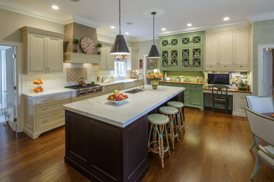 Example of a classic l-shaped medium tone wood floor eat-in kitchen design in Boston with a farmhouse sink, beige cabinets, marble countertops, beige backsplash, stainless steel appliances, an island and beaded inset cabinets