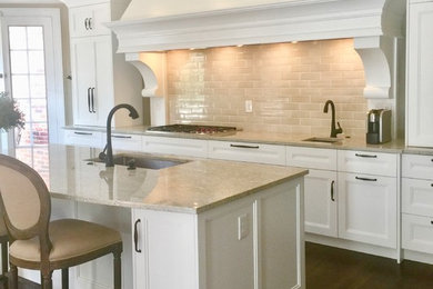Large transitional l-shaped dark wood floor and brown floor open concept kitchen photo in St Louis with an integrated sink, recessed-panel cabinets, white cabinets, granite countertops, beige backsplash, ceramic backsplash, stainless steel appliances, an island and beige countertops