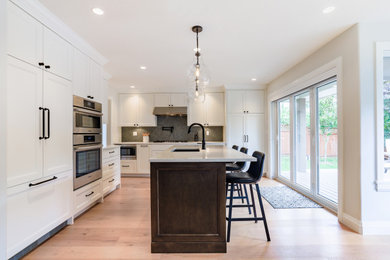 Inspiration for a traditional kitchen/diner in Vancouver with stainless steel appliances, an island and beige floors.
